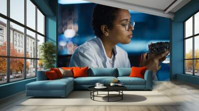 Modern Electronics Research and Development Facility: Beautiful Black Female Engineer Inspects Printed Circuit Board Motherboard. Scientist Designs Industrial PCB, Silicon Microchips, Semiconductors Wall mural