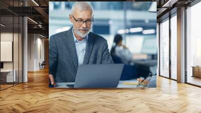 Modern Office: Portrait of Successful Middle Aged Bearded Corporate Businessman Working on a Laptop at his Desk, Smiling. Diverse Workplace with Professionals. Wall mural