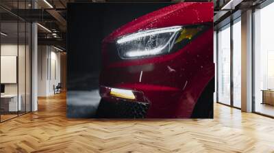 Modern Red Performance Vehicle with LED Headlights is Being Cleaned at a Dealership Car Wash. Close Up Commercial Photo of a Fast Car Being Washed in a Low Key Cinematic Studio Wall mural