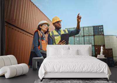 Multiethnic Female Industrial Engineer with Tablet and Black African American Male Supervisor in Hard Hats and Safety Vests Stand in Container Terminal. Colleagues Talk About Logistics Operations. Wall mural