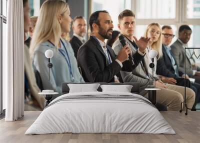 Multiethnic Male Technology Conference Attendee Sittign In Crowd And Using Microphone To Ask A Question Related To Presentation Of An Innovative Gadget. Middle Eastern Man At International Tech Forum. Wall mural