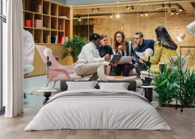 Multiethnic Young Group of People Brainstorming Together in a Meeting Room at the Office. Black Male E-commerce Coordinator Pitching His Ideas To Startup Management Board Members Using Tablet Wall mural