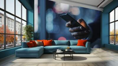 Night Office: Successful Black Businessman Wearing Suit Standing, Using Smartphone. CEO Browsing Internet, Managing Social Media Strategy in e-Commerce Software. Focus on Hand with Mobile Phone Wall mural