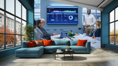 Office Conference Room Meeting Presentation: Black Businessman Talks, Uses TV Screen to Show Company Growth with Big Data Analysis, Graphs, Charts, Infographics. e-Commerce e-Business. Wall mural