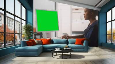 Portrait of a Black Female Medical Health Care Professional Working on Desktop Computer with Green Screen Mock Up Display in Hospital Office. Clinic Head Nurse is Appointing Prescriptions Online Wall mural