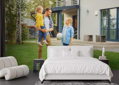 Portrait of a Happy Family of Three: Father, Daughter, Son. They Are Posing In Front of Camera on a Lawn Next to Their Country House. Dad is Holding the Girl in His Arms. Boy is Holding a Football. Wall mural