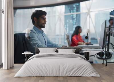 Portrait of an Indian Businessman Working on a Desktop Computer in a Fintech Startup Company. South Asian Financial Analyst Conducts Research in Emerging Asian Technology Stock Market Wall mural