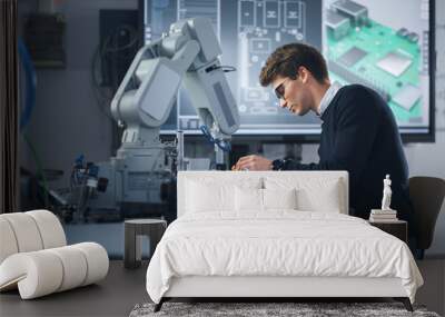 Portrait of Attentive Young Man Engineering Robotic Arm with Screwdriver at Isolated Room. Science Student Holding an Experiment with Bionic Arm. High-Tech Science, Education and Learning Concept Wall mural