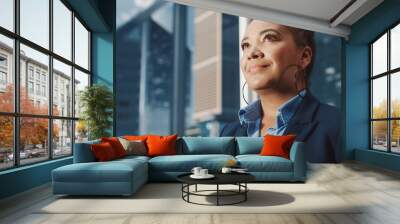 Portrait of Successful Black Businesswoman Riding Glass Elevator to Office in Modern Business Center. African American Female Looking at Modern Skyscrapers Out of the Panorama Window in the Lift. Wall mural