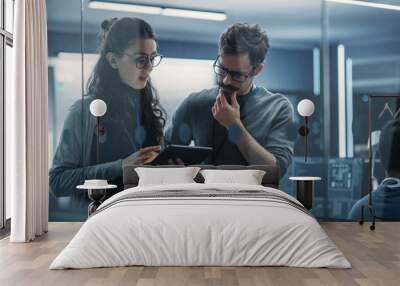 Portrait of Two Creative Young Female and Male Engineers Using Tablet Computer to Analyze and Discuss How to Proceed with the Artificial Intelligence Software. Standing in High Tech Research Office Wall mural