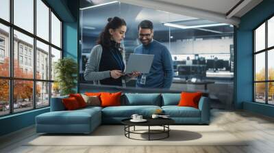 Portrait of Two Happy Female and Male Engineers Using Laptop Computer to Analyze and Discuss How to Proceed with the Artificial Intelligence Software. Casually Chatting in High Tech Research Office Wall mural