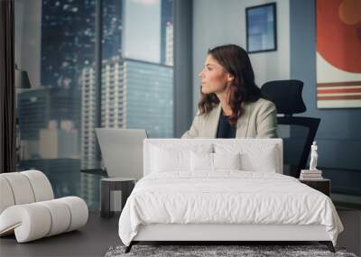 portrait of young successful caucasian businesswoman sitting at desk working on laptop computer in c Wall mural