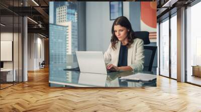 Portrait of Young Successful Caucasian Businesswoman Sitting at Desk Working on Laptop Computer in City Office. Ambitious Corporate Manager Plan Investment Strategy for e-Commerce Project. Wall mural