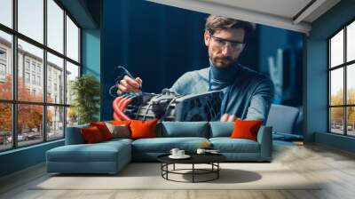 Professional Automotive Engineer in Glasses with a Computer and Inspection Tools is Testing an Used Electric Engine in a High Tech Laboratory with a Concept Car Chassis. Wall mural