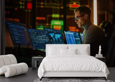 Professional IT Technical Support Specialist Making an Intercom Announcement on a Microphone and Working on Desktop Computer in Monitoring Control Room with Big Digital Screens with Server Data. Wall mural