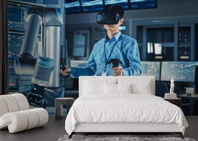 Professional Japanese Development Engineer in Blue Shirt is Controlling a Futuristic Robotic Arm with a Virtual Reality Headset and Joysticks in a High Tech Research Laboratory with Modern Equipment. Wall mural