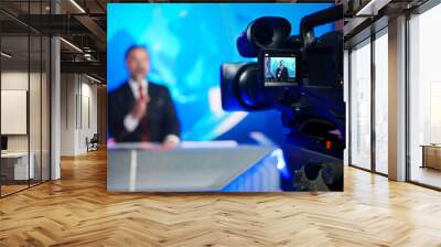 Professional TV Camera Standing in Live News Studio with Anchor seen in Small Display. Unfocused TV Broadcasting Channel with Presenter, Newscaster Talking. Mock-up Television Channel Newsroom Set Wall mural