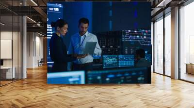 Project Leader and Chief Executive Discuss Data Shown on a Laptop. In Background Big Screen Showing Infographics of Infrastructure, Charts, System Analysis. Telecommunications Control Room Wall mural