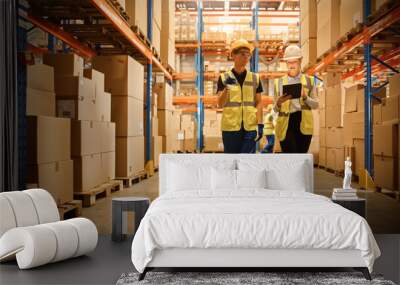 Retail Warehouse full of Shelves with Goods in Cardboard Boxes, Male Worker and Female Supervisor Holding Digital Tablet Discuss Product Delivery while Scanning Packages. Distribution Logistics Center Wall mural