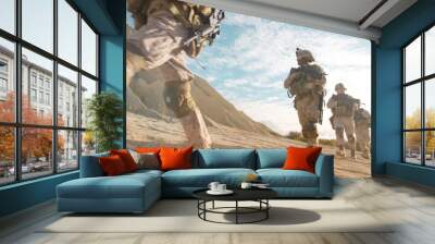 Squad of Fully Equipped and Armed Soldiers Moving in Single File in the Desert. Wall mural