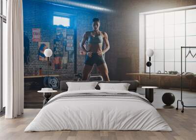 Strong and Fit Beautiful Athletic Woman in Sport Top and Shorts is Doing Squat Exercises in a Loft Style Industrial Gym with Motivational Posters. It's Part of Her Cross Fitness Training Workout. Wall mural