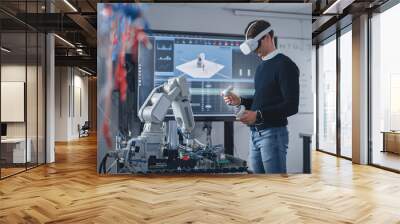 Student Engineer Wearing Virtual Reality Headset Holding Controllers and Moving Bionic Claw Under his Control During the Lesson. University with Modern Equipment. Computer Science Education Concept. Wall mural