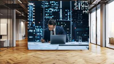 Successful Handsome Businessman Working on Laptop Computer in Big City Office Late in the Evening. Finance Investment Analyst Checking Line and Pie Graphs from Project Management Report. Wall mural