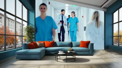 Surgeon and Female Doctor Walk Through Hospital Hallway, They Consult Digital Tablet Computer while Talking about Patient's Health. Modern Bright Hospital with Professional Staff. Wall mural