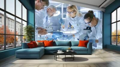 team of medical research scientists work on a new generation disease cure. they use microscope, test Wall mural