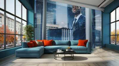 Thoughtful African-American Businessman in a Perfect Tailored Suit Standing in His Office Looking out of the Window on Big City. Successful Investment Manager Planning Strategy. Outside Shot Wall mural