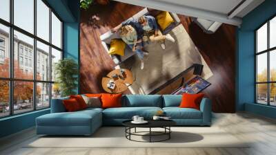 Top View Apartment: Lovely Couple Watching Television in the Stylish Living Room. Looking at the TV Display and Eating Popcorn. Girlfriend and Boyfriend Enjoy Sitcom on Streaming Service on Couch. Wall mural