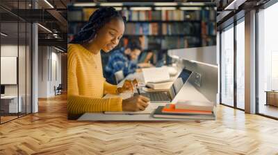 University Library: Gifted Beautiful Black Girl Sitting at the Desk, Uses Laptop, Writes Notes for the Paper, Essay, Study for Class Assignment. Diverse Group of Students Learning, Studying for Exams. Wall mural