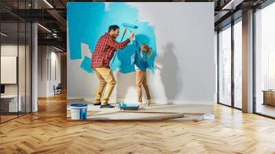 Young Father is Showing How to Paint Walls to Cute Small Daughter. They Give High Give to Each other. Rollers are Covered in Light Blue Paint. Room Renovations at Home. Wall mural