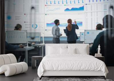 Zoom Out Back View Of Indian Man And Hispanic Woman Discussing Financial Reports On Digital Screen in Monitoring Room. Diverse Colleagues Working On Desktop Computers For Investment Management Company Wall mural