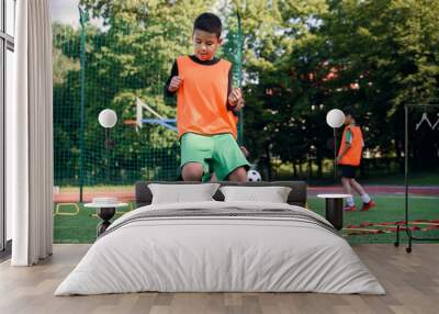 Children's football players during team training before an important match. Exercises for the youth football team. Wall mural