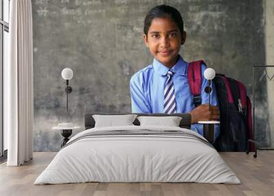 Portrait of happy indian teenager school boy with backpack holding books. Smiling young asian male kid looking at camera. Wall mural