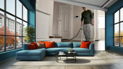 Caucasian man with down syndrome vacuuming at home Wall mural