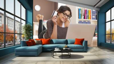 Happy woman doing online shopping at home Wall mural