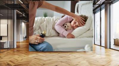 Mother taking care of her ill daughter at home Wall mural