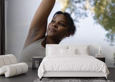 Plus sized African American woman stretching at the park in a  summer day Wall mural