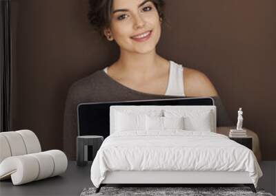 Smiling woman showing on screen of contemporary laptop Wall mural