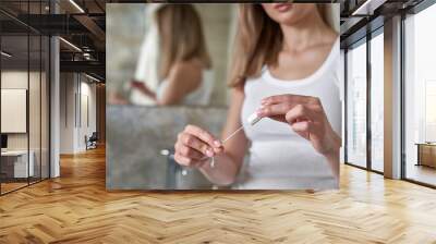 Unrecognizable young caucasian woman standing in the bathroom and holding a tampon Wall mural