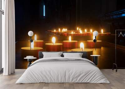 the candle flames lighten the darkness Wall mural