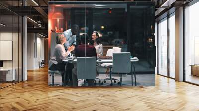 The hours are worth the success. colleagues having a meeting during a late night in a modern office. Wall mural