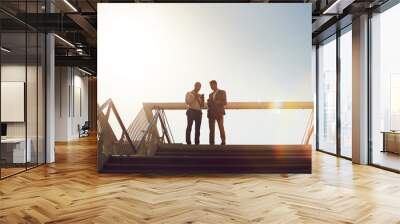 Lets set up an appointment to discuss ideas. Low angle shot of two businessmen using a cellphone on top of a staircase outside. Wall mural