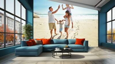 Parents, children and beach for high five in summer for travel vacation, ocean sunshine or sibling development. Man, woman and kids on sand for holiday relax walking or outdoor, clean air or smile Wall mural