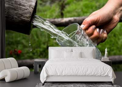 Big Glass Filled With Clear Mountain Drinking Water From A Wooden Spring Wall mural