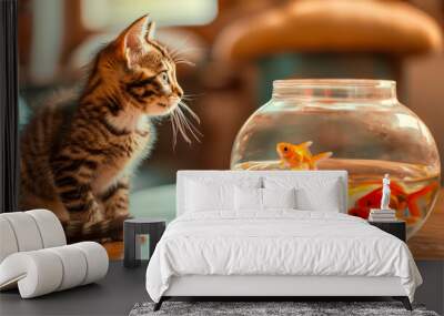 A beautiful fluffy cat looking at a goldfish in an aquarium on the table. Wall mural