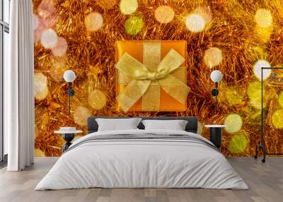 Christmas gift box on background of shiny golden tinsel Wall mural