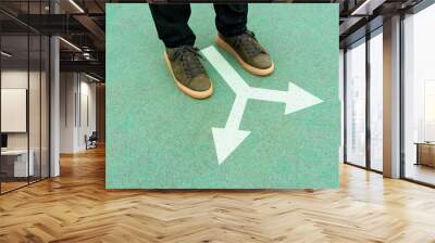 Feet and two arrows painted on blue surface Wall mural